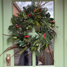 Load image into Gallery viewer, Christmas wreath with greenery, berries, and feathers on a green door.
