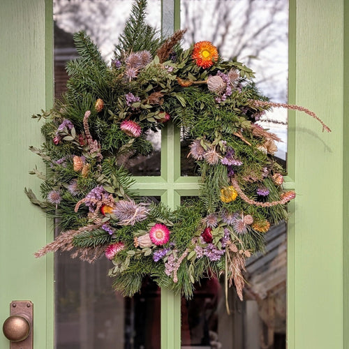 Decorative wreath with flowers and greenery on a door
